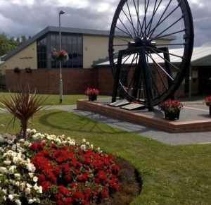 Photo of Thornley Village Centre with flowerbed and pit wheel in front